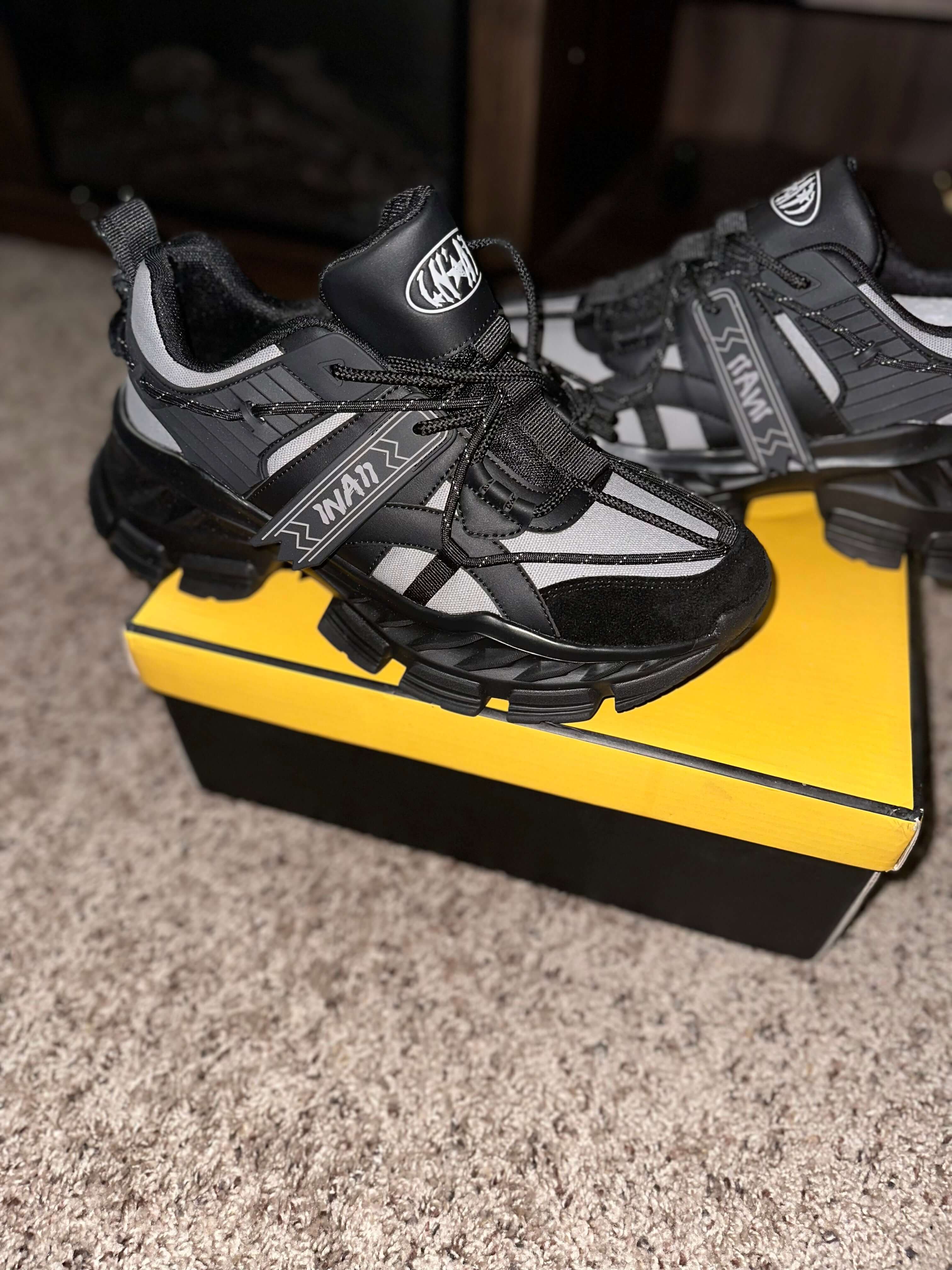 1 N' A11 Charcoal Glaze sneakers in black and grey on a yellow shoebox, showcasing stylish and durable design for everyday wear