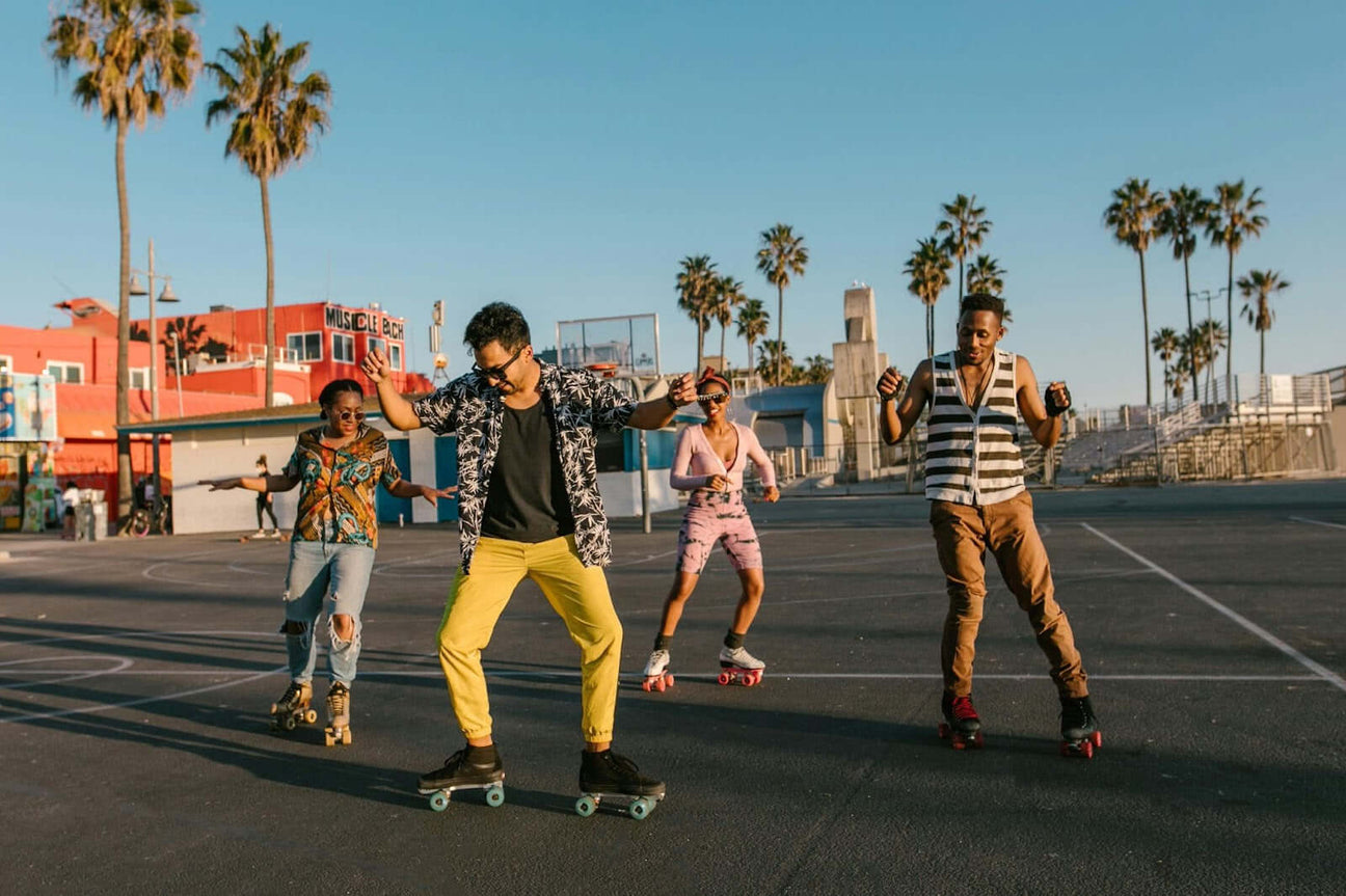 A group of friends roller skating outdoors in a sunny urban park, wearing casual streetwear and colourful outfits, capturing the fun and relaxed vibe of the scene.