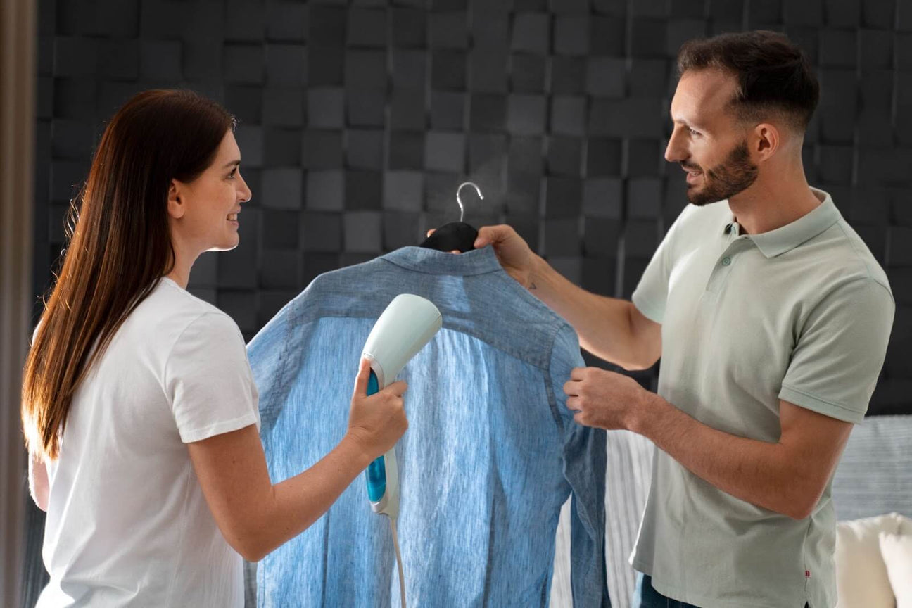 A woman steaming a blue shirt held by a man