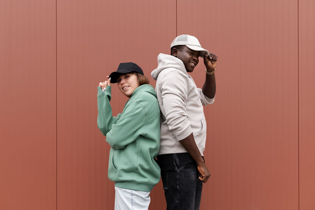 Two stylish individuals rocking trendy streetwear outfits featuring oversized hoodies and caps, showcasing urban fashion essentials for a modern, casual look.